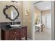 Bathroom showcasing an ornate mirror, dark wood vanity, and a view into the next room at 995 Westlake Hills Dr, Columbus, IN 47201