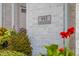 Address plaque on the exterior wall framed by beautiful flowers, adding charm and curb appeal at 995 Westlake Hills Dr, Columbus, IN 47201