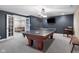 Spacious game room with ping pong table, mounted TV, modern lighting, and open doorway to a seating area at 995 Westlake Hills Dr, Columbus, IN 47201
