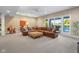 Living room with neutral walls, carpet, and a large leather couch and view of the pool at 995 Westlake Hills Dr, Columbus, IN 47201