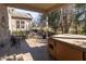 Back patio with hot tub, chairs, and an outdoor table near manicured trees and landscaping at 1115 Morningside Ct, Greenfield, IN 46140