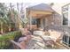 An outdoor patio area featuring wicker furniture, brick columns, and a hot tub in the background at 1115 Morningside Ct, Greenfield, IN 46140