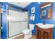 Well-lit bathroom features a shower, toilet, sink, and dark blue walls at 1115 Morningside Ct, Greenfield, IN 46140