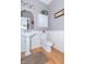 Powder room with pedestal sink, white wainscoting, wood floors, and neutral paint at 1115 Morningside Ct, Greenfield, IN 46140