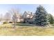 Beautifully landscaped front yard with mature trees framing a charming brick home at 1115 Morningside Ct, Greenfield, IN 46140