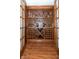 Wine cellar with custom shelving for ample bottle storage, wine glass hangers and tile flooring at 1115 Morningside Ct, Greenfield, IN 46140