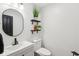 Stylish powder room with modern fixtures, decorative shelves, and a round mirror adds a touch of elegance at 11907 Ledgestone Cir, Fishers, IN 46037
