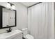 Modern bathroom features a sleek vanity with dark fixtures, a large mirror and a bathtub with a white curtain at 11907 Ledgestone Cir, Fishers, IN 46037