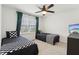 Bright bedroom features two twin beds with checkered blankets, ceiling fan, and window with green curtains at 11907 Ledgestone Cir, Fishers, IN 46037
