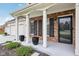 Inviting front porch with classic columns, black accents, and neatly trimmed bushes showcasing charm and style at 11907 Ledgestone Cir, Fishers, IN 46037