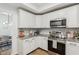 Well-lit kitchen with white cabinets, stainless steel appliances, and sleek countertop backsplash at 11907 Ledgestone Cir, Fishers, IN 46037