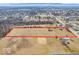 This aerial view shows the property outlined in red with treescapes and nearby houses at 1229 N German Church Rd, Indianapolis, IN 46229