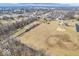 This aerial view shows the property with treescapes, waterway and nearby houses at 1229 N German Church Rd, Indianapolis, IN 46229