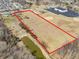 This aerial view shows the property outlined in red with pond, baseball diamond, and treescapes at 1229 N German Church Rd, Indianapolis, IN 46229