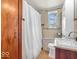 The bathroom features tile flooring, a shower with white curtain, and a toilet at 1229 N German Church Rd, Indianapolis, IN 46229