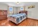 A well-lit bedroom offers hardwood floors, natural light, and a beautiful wooden dresser at 1229 N German Church Rd, Indianapolis, IN 46229