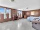Spacious bedroom with wood-paneled walls, multiple windows, and a comfortable seating area at 1229 N German Church Rd, Indianapolis, IN 46229