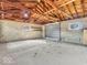 Large detached garage with exposed rafter ceiling, concrete floors, and garage door at 1229 N German Church Rd, Indianapolis, IN 46229