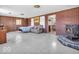 Open-concept living room featuring wood paneling, cozy seating, and a classic wood-burning fireplace at 1229 N German Church Rd, Indianapolis, IN 46229