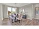 Dining room features a wooden table with seating for six, a modern chandelier, and large windows with natural light at 1249 Sika Ln, Greenwood, IN 46143