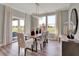 Dining area with wood table, modern light fixture, large windows overlooking the green space, and sliding glass door at 1249 Sika Ln, Greenwood, IN 46143