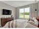 Comfortable main bedroom with a view of a large window, mounted television, and light neutral colors at 1249 Sika Ln, Greenwood, IN 46143