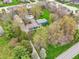 Aerial view of a spacious blue house on an expansive lot, complemented by a private pool and verdant tree coverage at 1250 W 141St St, Carmel, IN 46032
