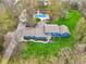 Aerial view of a blue home on a lush green lot with a pristine private pool and meticulously maintained landscaping at 1250 W 141St St, Carmel, IN 46032