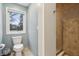 Well-lit bathroom featuring a toilet, walk-in shower, and a bright window at 1250 W 141St St, Carmel, IN 46032
