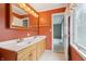 Well-lit bathroom with a double vanity, light wood cabinets and a glimpse into an adjacent room at 1250 W 141St St, Carmel, IN 46032