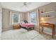 Comfortable bedroom with neutral carpet, ceiling fan, two windows, desk, and wooden decor at 1250 W 141St St, Carmel, IN 46032