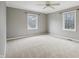 Spacious bedroom with neutral walls and carpet, two large windows, and a ceiling fan for comfortable living at 1250 W 141St St, Carmel, IN 46032