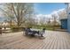Outdoor deck with a wooden table and chairs, overlooking the backyard and treeline views at 1250 W 141St St, Carmel, IN 46032