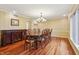 Formal dining room with hardwood floors, large window, chandelier and striped wallpaper offers a classic elegant appeal at 1250 W 141St St, Carmel, IN 46032