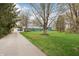 Long driveway leading to a lovely blue home with a spacious front yard and mature trees, perfect for outdoor enjoyment at 1250 W 141St St, Carmel, IN 46032