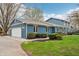 Side of a blue home with a two-car garage, showcasing well-maintained landscaping and classic suburban design at 1250 W 141St St, Carmel, IN 46032