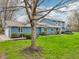 View of a charming home with an attached garage and well-kept lawn, framed by mature trees at 1250 W 141St St, Carmel, IN 46032