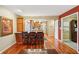 Open-concept kitchenette with wood cabinets, bar seating, and view to the main kitchen area with a wood floor at 1250 W 141St St, Carmel, IN 46032