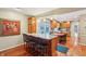 Charming kitchenette features granite counters, wood cabinets, and breakfast bar with seating for entertaining guests with wood floors at 1250 W 141St St, Carmel, IN 46032