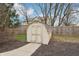 Backyard storage shed with double doors and a pathway surrounded by trees and a wooden fence at 1250 W 141St St, Carmel, IN 46032