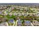 A wide aerial view of a suburban neighborhood, showing a diverse range of homes, tree-lined streets, and open green spaces at 12526 Pembrooke Cir, Carmel, IN 46032