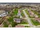 An aerial perspective of a residential neighborhood with tree-lined streets, offering an overview of community layout and lush greenery at 12526 Pembrooke Cir, Carmel, IN 46032