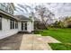View of the home's backyard, featuring mature trees, a concrete patio, and a lush lawn at 12526 Pembrooke Cir, Carmel, IN 46032