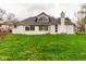The rear exterior of the house showcases large windows offering plenty of natural light and access to the expansive green lawn at 12526 Pembrooke Cir, Carmel, IN 46032