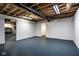 Unfinished basement space with painted floors, white walls, and exposed ceiling; ready for your personal touch at 12526 Pembrooke Cir, Carmel, IN 46032