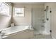 Bright bathroom with corner tub, glass shower, and neutral-toned tile at 12526 Pembrooke Cir, Carmel, IN 46032
