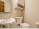 Compact half-bathroom featuring a pedestal sink and modern toilet at 12526 Pembrooke Cir, Carmel, IN 46032