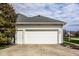 Attached two car garage featuring concrete driveway, side door, and neutral paint scheme at 12526 Pembrooke Cir, Carmel, IN 46032