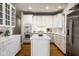 Well-lit kitchen with white cabinets, tiled countertops, and stainless steel appliances at 12526 Pembrooke Cir, Carmel, IN 46032