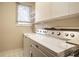 Functional laundry room with washer, dryer, and upper storage cabinets at 12526 Pembrooke Cir, Carmel, IN 46032